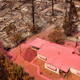 An aerial view shows a home covered in fire retardant near dozens of properties destroyed at the Creekside Mobile Home Park after the Cache fire ripped through the area in Clearlake, California, on Aug. 19, 2021